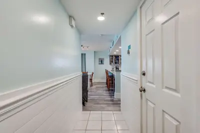 a hallway with white walls and a hallway with a stairway at Watercrest 1510 - Timeless Memories Stunning views in Panama City Beach