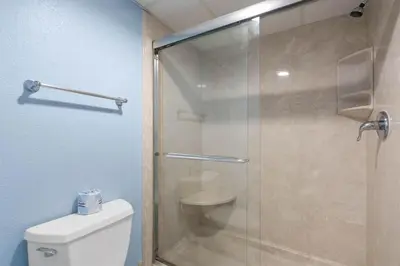 a bathroom with a glass shower with a toilet at Watercrest 1509 - Sleeps 8 Amazing sunsets in Panama City Beach