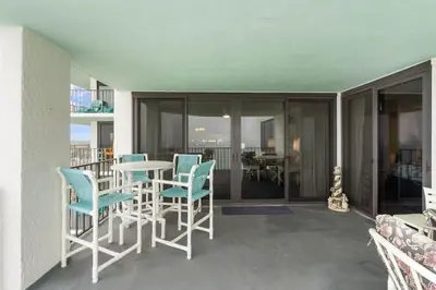 a room with a table and chairs and a balcony at Watercrest 1509 - Sleeps 8 Amazing sunsets in Panama City Beach