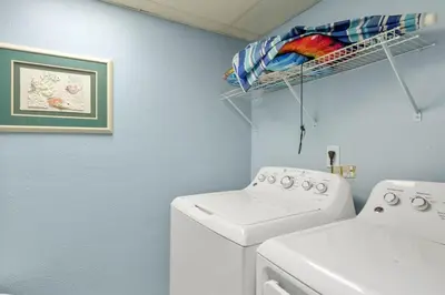 a laundry room with a washing machine and a drying rack at Watercrest 1509 - Sleeps 8 Amazing sunsets in Panama City Beach