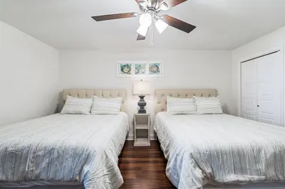two beds in a bedroom with a ceiling fan at Watercrest 1405 - Crystal-Gulf Overlook - Sleeps 8 in Panama City Beach