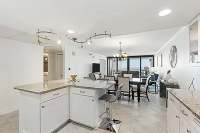 a kitchen with white cabinets and a dining room at Watercrest 1405 - Crystal-Gulf Overlook - Sleeps 8 in Panama City Beach