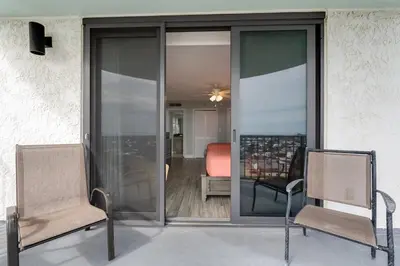 two chairs sitting on a patio with a room at Watercrest 1201 - Swell Life - Sleeps 8 2 BR 2 BA in Panama City Beach