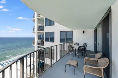 a balcony with chairs and tables and the ocean at Watercrest 1201 - Swell Life - Sleeps 8 2 BR 2 BA in Panama City Beach