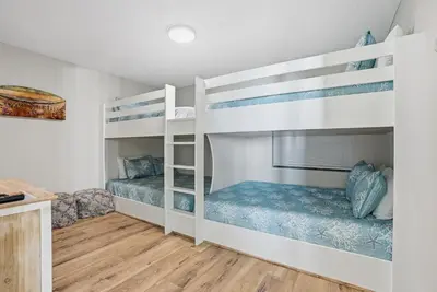 two bunk beds in a room with wooden floors at Watercrest 207 3 BR 3 BA with 2 Beachfront Masters in Panama City Beach