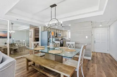 a dining room and kitchen with a table and chairs at Watercrest 207 3 BR 3 BA with 2 Beachfront Masters in Panama City Beach