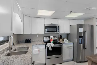 a kitchen with white cabinets and stainless steel appliances at Watercrest 210- Sleeps 12 - Thomas Drive Retreat in Panama City Beach