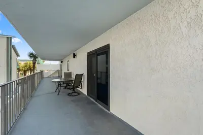 a balcony with a table and a laptop on it at Watercrest 210- Sleeps 12 - Thomas Drive Retreat in Panama City Beach