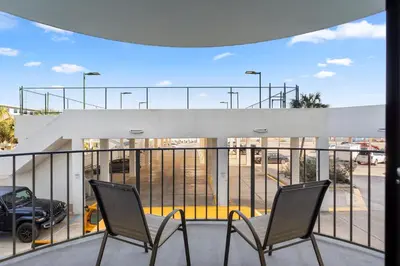 two chairs on a balcony overlooking a parking lot at Watercrest 210- Sleeps 12 - Thomas Drive Retreat in Panama City Beach
