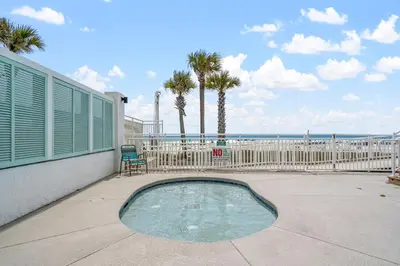 a swimming pool with a fence and palm trees at Watercrest 401 Amazing wrap around balcony in Panama City Beach