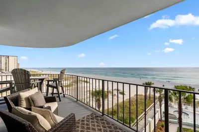 a balcony with chairs and a view of the beach at Watercrest 401 Amazing wrap around balcony in Panama City Beach