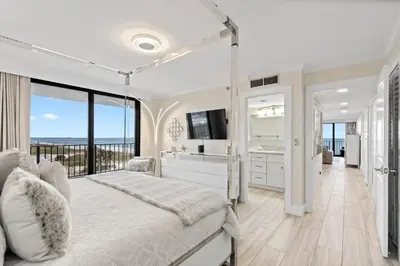 a bedroom with a large bed and a balcony at Watercrest 401 Amazing wrap around balcony in Panama City Beach