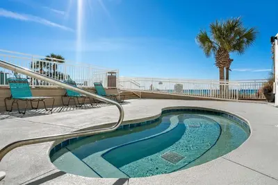 a small swimming pool with chairs and a palm tree at Watercrest 209 White-Sands Getaway - Sleeps 8 in Panama City Beach