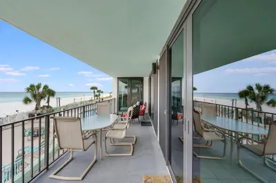 a balcony with tables and chairs and the beach at Watercrest 203 - Emerald Shore Overlook 2 BR 2 BA in Panama City Beach