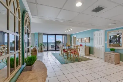 a dining room and living room with a table and chairs at Watercrest 203 - Emerald Shore Overlook 2 BR 2 BA in Panama City Beach