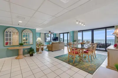 a living room with a table and chairs at Watercrest 203 - Emerald Shore Overlook 2 BR 2 BA in Panama City Beach