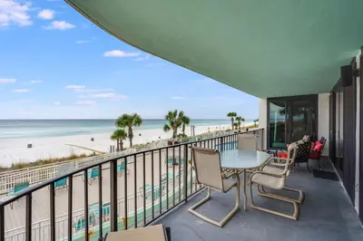 a balcony with a table and chairs and the beach at Watercrest 203 - Emerald Shore Overlook 2 BR 2 BA in Panama City Beach