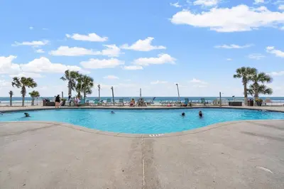 a swimming pool at the beach with people in it at Watercrest 203 - Emerald Shore Overlook 2 BR 2 BA in Panama City Beach