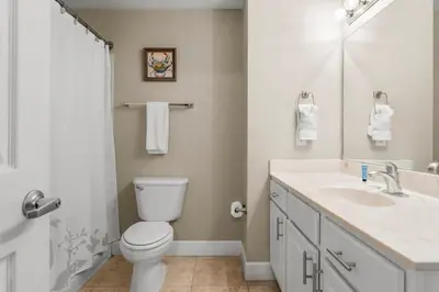 a white bathroom with a toilet and a sink at Family-Friendly Gulf-Front Condo w/Beach Access in Panama City Beach
