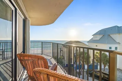 a balcony with a chair and a view of the ocean at Commodore 410 in Panama City Beach