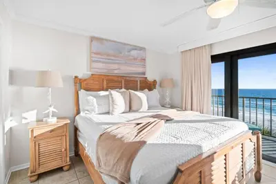 a bedroom with a bed with a view of the ocean at Commodore 410 in Panama City Beach