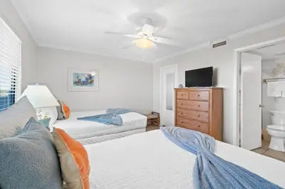 a bedroom with two beds and a ceiling fan at Commodore 410 in Panama City Beach