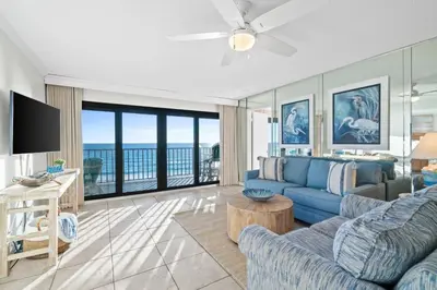 a living room with a blue couch and a television at Commodore 410 in Panama City Beach
