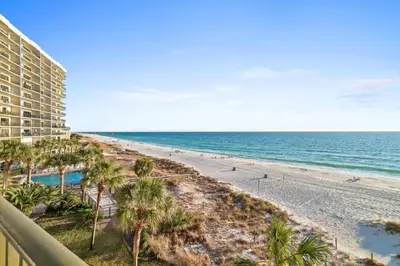 a view of the beach from the balcony of a resort at Commodore 410 in Panama City Beach