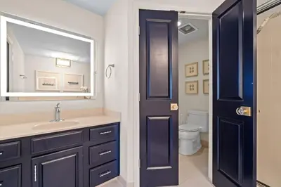 a bathroom with a sink and a mirror and a toilet at Grande Surf Club 11E in Panama City Beach