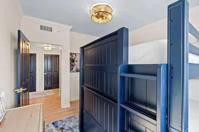 a bedroom with a blue bunk bed and a table at Grande Surf Club 11E in Panama City Beach