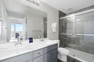 a bathroom with two sinks and a shower and a toilet at Family-Friendly 4BR Beachfront Retreat w/ Indoor & Outdoor Pools in Panama City Beach