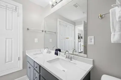 a white bathroom with a sink and a mirror at Family-Friendly 4BR Beachfront Retreat w/ Indoor & Outdoor Pools in Panama City Beach