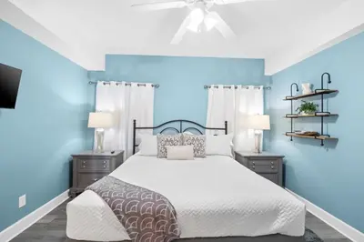 a bedroom with a bed with blue walls and a ceiling at Family-Friendly 4BR Beachfront Retreat w/ Indoor & Outdoor Pools in Panama City Beach