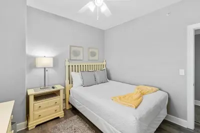 a bedroom with a bed with a yellow blanket on it at Family-Friendly 4BR Beachfront Retreat w/ Indoor & Outdoor Pools in Panama City Beach