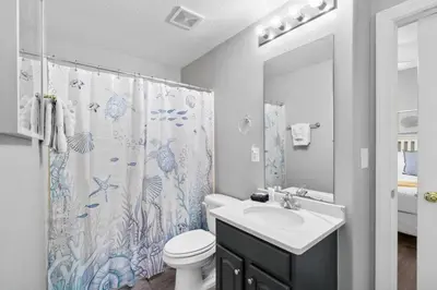 a bathroom with a sink and a toilet and a shower curtain at Family-Friendly 4BR Beachfront Retreat w/ Indoor & Outdoor Pools in Panama City Beach