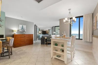 a dining room and living room with a dining table at Sunbird 407E - Pearl Gulf Getaway - Sleeps 4 in Panama City Beach