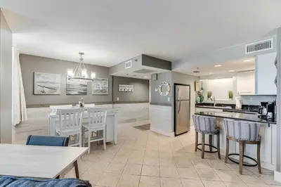 a kitchen and living room with a table and chairs at Sunbird 407E - Pearl Gulf Getaway - Sleeps 4 in Panama City Beach