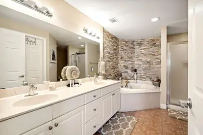 a large bathroom with two sinks and a tub and a tubermott at Tidewater 2405 - Tidewater Peak Sleeps 6 - 2Br 2Ba in Panama City Beach