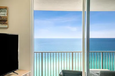 a room with a view of the ocean from a balcony at Tidewater 2405 - Tidewater Peak Sleeps 6 - 2Br 2Ba in Panama City Beach