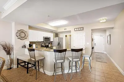 a kitchen with chairs and a bar in a room at Tidewater 2405 - Tidewater Peak Sleeps 6 - 2Br 2Ba in Panama City Beach