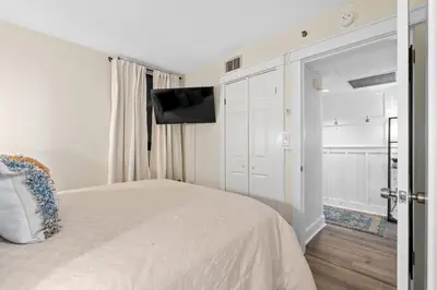 a bedroom with a bed and a flat screen tv at Sunbird 110W 1 BR 1 BA Located right next to pool in Panama City Beach