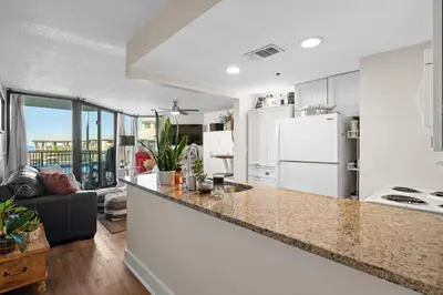 a kitchen with white appliances and a living room at Sunbird 110W 1 BR 1 BA Located right next to pool in Panama City Beach