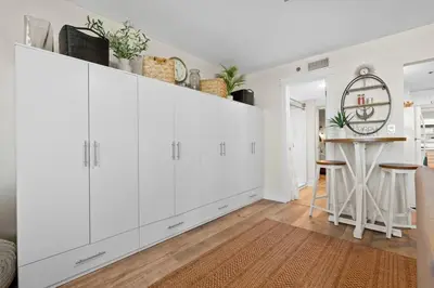 a white kitchen with white cabinets and a table at Sunbird 110W 1 BR 1 BA Located right next to pool in Panama City Beach