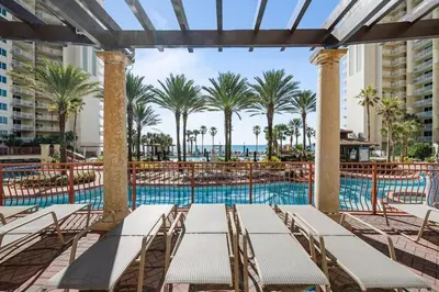 a pool with chaise lounge chairs and palm trees at Shores of Panama 926 - Shore-Gulf Peak- 2 BR 2 BA in Panama City Beach