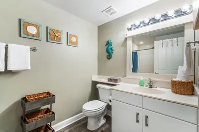 a bathroom with a toilet and a sink and a mirror at Shores of Panama 926 - Shore-Gulf Peak- 2 BR 2 BA in Panama City Beach