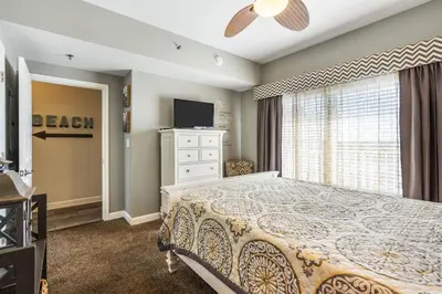 a bedroom with a bed and a television and a window at Shores of Panama 926 - Shore-Gulf Peak- 2 BR 2 BA in Panama City Beach