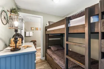 a bedroom with bunk beds and a desk with a lamp at Shores of Panama 926 - Shore-Gulf Peak- 2 BR 2 BA in Panama City Beach