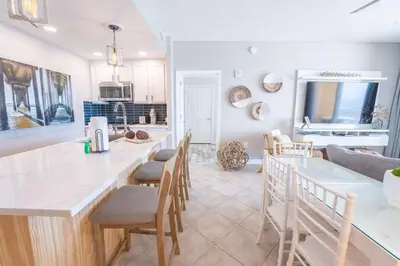 a kitchen and living room with a table and chairs at Sterling Reef 503 - Pierview Oasis - Sleeps 6 in Panama City Beach