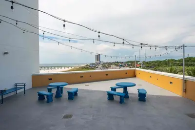 a balcony with blue tables and a view of the ocean at Sterling Reef 503 - Pierview Oasis - Sleeps 6 in Panama City Beach