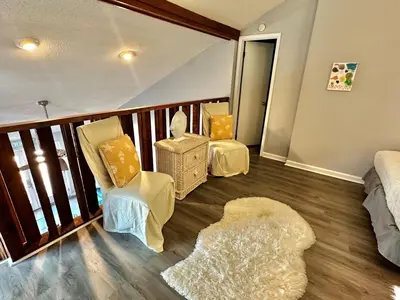 a room with two chairs and a bed and a balcony at Horizon South 33D - Sunstead Retreat - Sleeps 6 in Panama City Beach